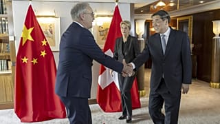 Le ministre suisse de l'Economie Guy Parmelin, à gauche, serre la main du vice-Premier ministre chinois He Lifeng vendredi (10/05/2025)