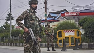 Soldados paramilitares indianos montam guarda num ponto de controlo temporário numa estrada que conduz ao aeroporto depois de terem sido ouvidas fortes explosões em Srinagar,
