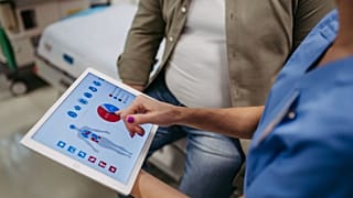 A health worker goes over a patient's chart.