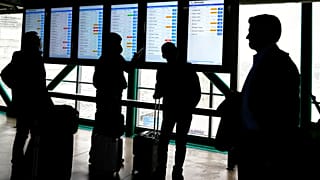 Reisende informieren sich am O'Hare International Airport in Chicago über den Flugstatus der American Airlines.