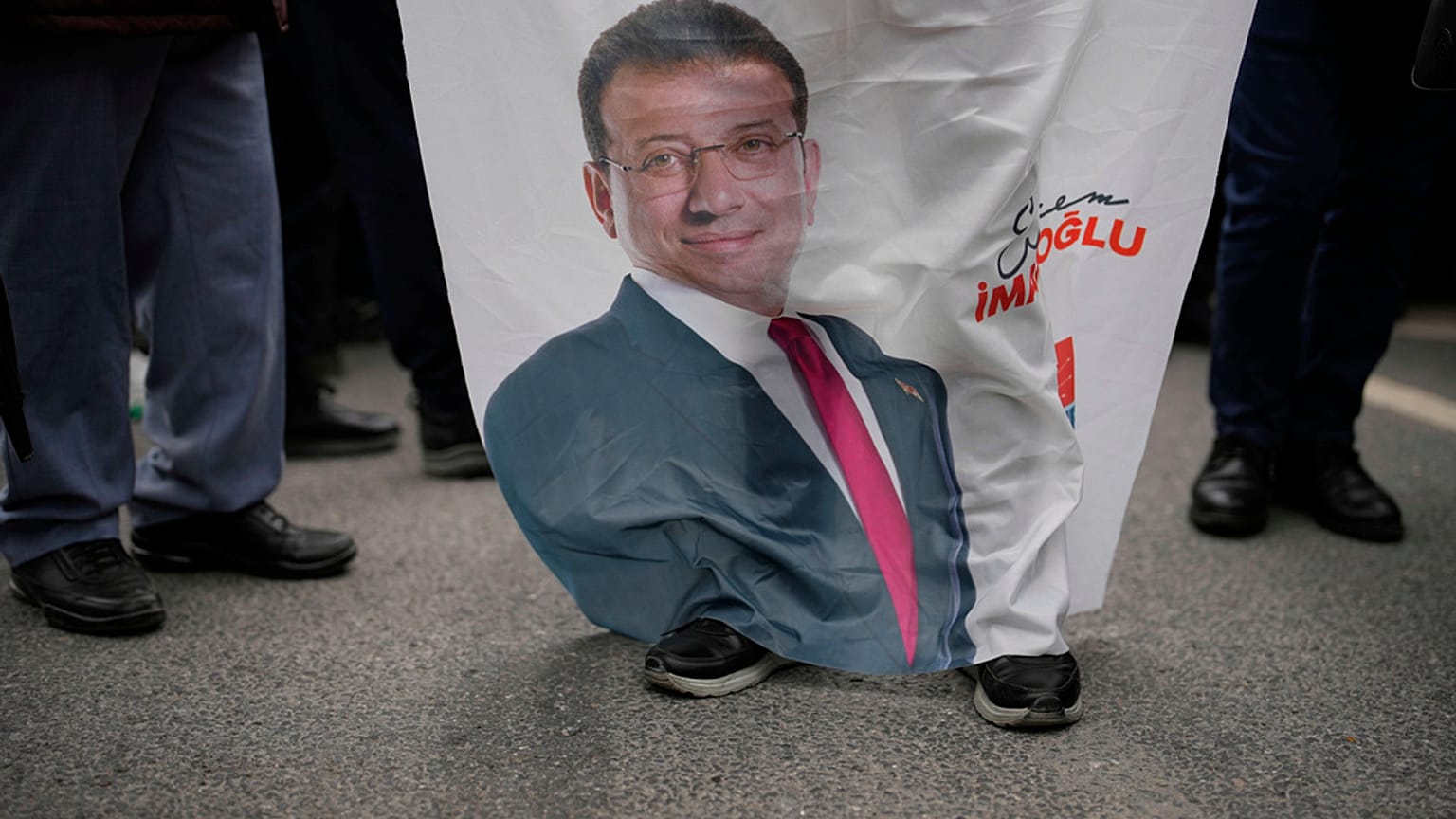 Ekrem İmamoğlu'nun tutuklanmasına tepki gösteren insanların düzenlediği protestolar sırasında bir kişi İmamoğlu pankartı taşırken, 19 Mart 2025
