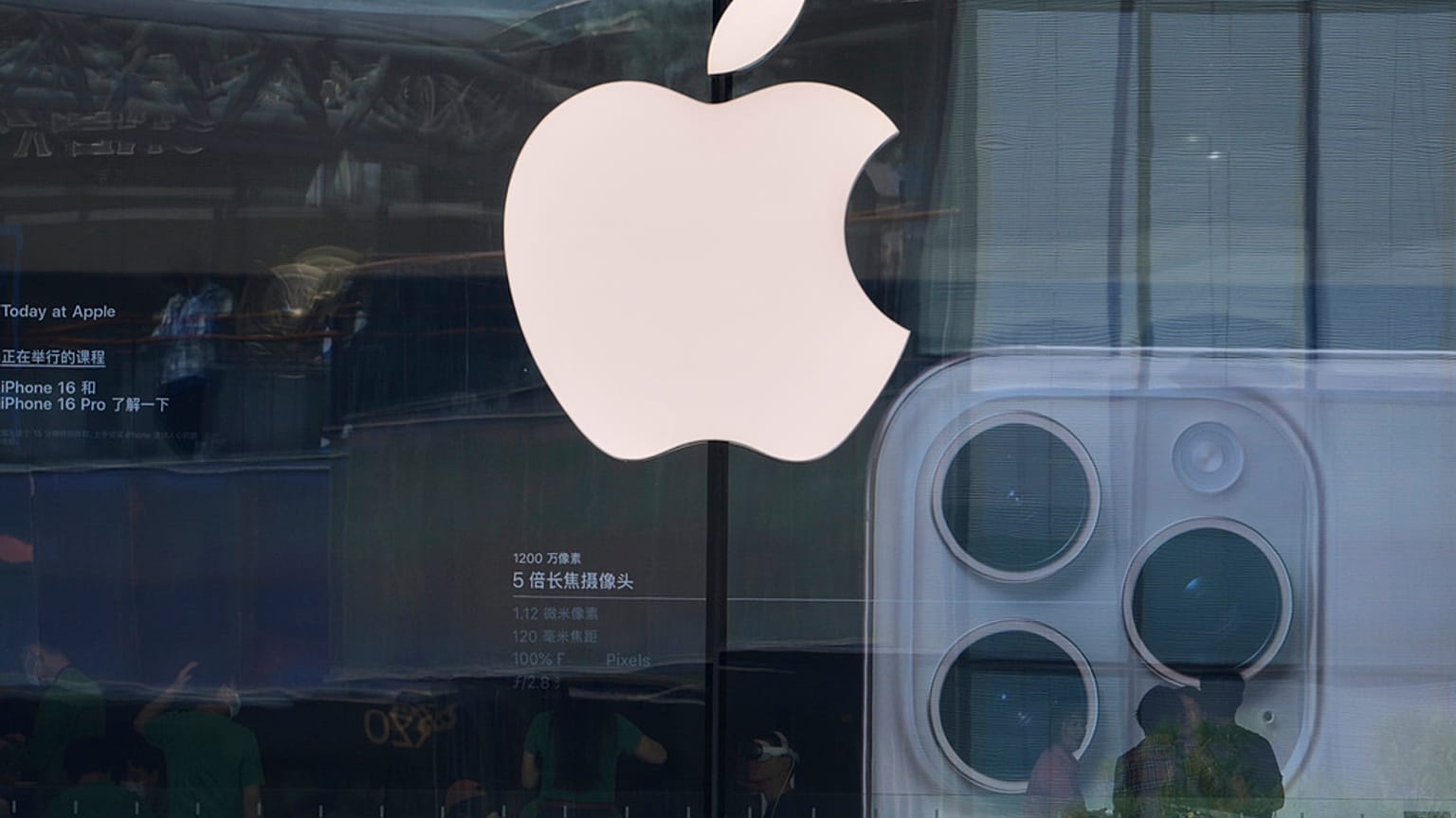 أشخاص يزورون متجرًا لشركة Apple للترويج لهاتف iPhone 16 في مركز تسوق خارجي في بكين