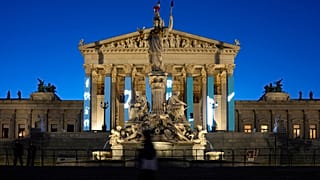 Menschen gehen am Sonntag, 29. September 2024, nach Schließung der Wahllokale vor dem Parlamentsgebäude in Wien, Österreich, spazieren.