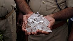 DOSYA: Bir Hint polisi Azamgarh bölgesindeki Narawn köyünde bir kuyuda ele geçirilen kaçak içki paketlerini gösteriyor, 20 Ekim 2013