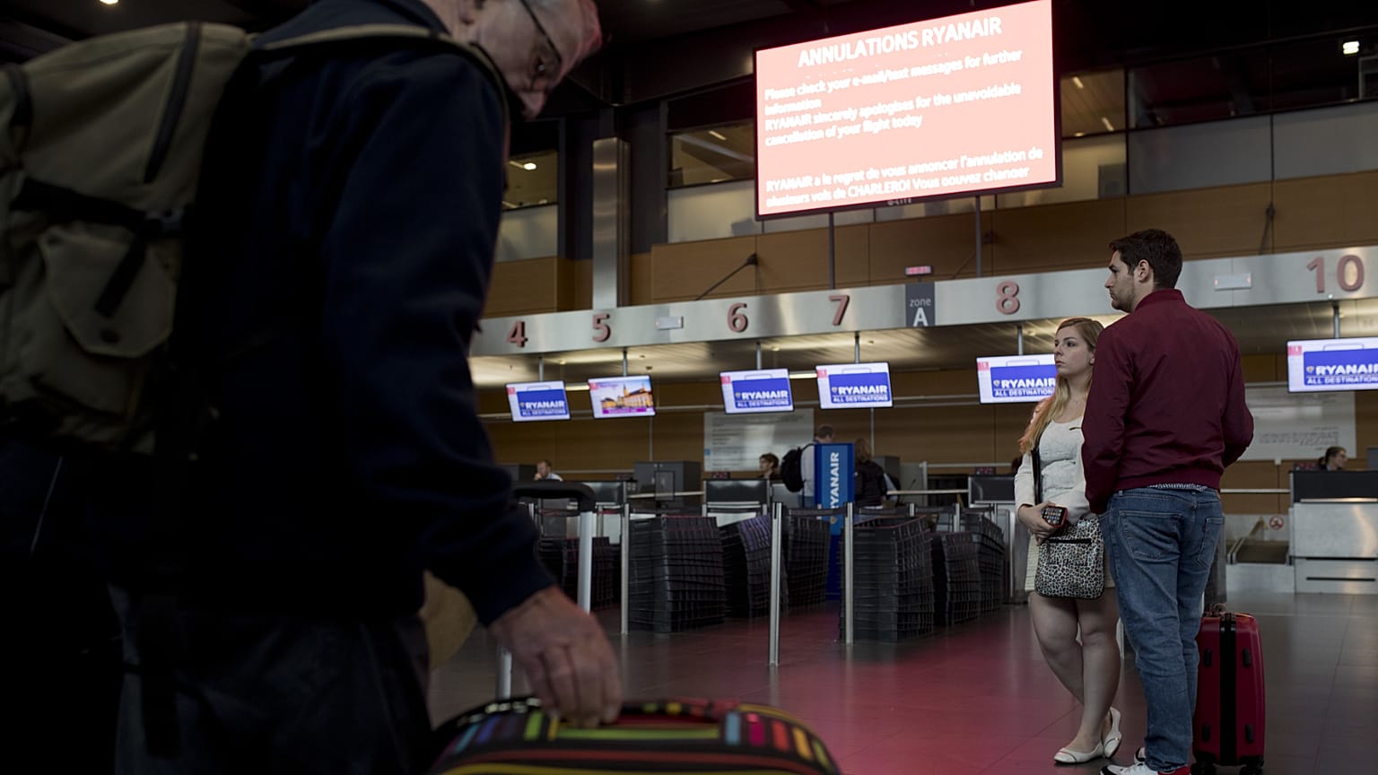 Passengers stand in front of Ryanair airline check-in desks at Charleroi airport, 28 September, 2018
