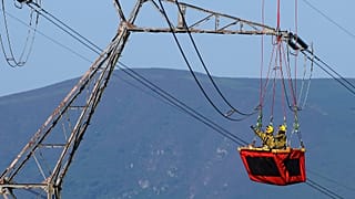Técnicos trabalham em linhas de alta tensão acima da cidade de Ascain, no sudoeste de França.