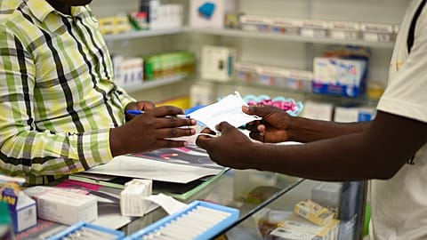 FILE — A man buys a face mask at a pharmacy in Kitwe, Zambia, Feb. 6, 2020