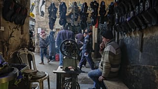 Um comerciante sentado no interior da sua loja no mercado da cidade velha de Damasco, 9 de janeiro de 2025