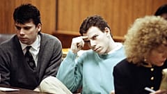 ARQUIVO - Lyle Menendez, à esquerda, e o seu irmão, Erik, sentam-se à mesa da defesa durante uma audiência num tribunal de Beverly Hills, Califórnia, a 3 de abril de 1991.