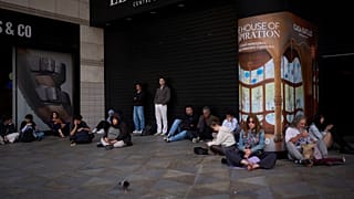 People wait outside a closed shopping center, during a blackout in Barcelona, 28 April 2025
