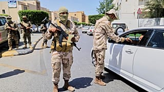جنود ليبيون يفتشون المركبات المارة عند نقطة تفتيش في طرابلس، ليبيا، يوم الثلاثاء، 13 مايو 2025