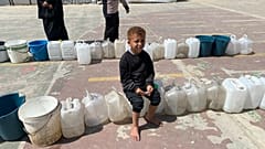 طفل ينتظر تعبئة المياه في دير البلح بقطاع غزة  بتاريخ 14 مايو أيار 2025