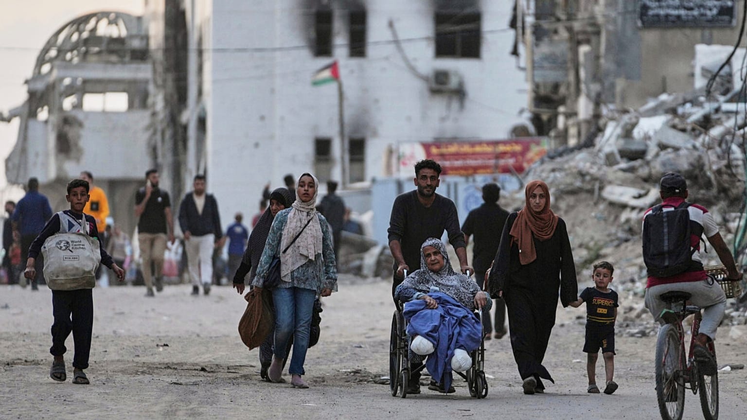 Palestinesi evacuano dopo che l'esercito israeliano ha emesso un avviso di evacuazione per diverse scuole e un ospedale nel quartiere Rimal di Gaza City, mercoledì 14 maggio 2025.