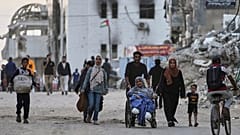 Os palestinianos evacuam depois de o exército israelita ter emitido um aviso de evacuação para várias escolas e um hospital no bairro de Rimal, na cidade de Gaza, na quarta-feira, 14 de maio de 2025.