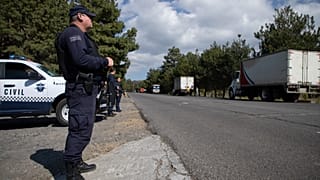 FILE - La polizia sorveglia i camion carichi di avocado diretti alla città di Uruapan a Santa Ana Zirosto, nello Stato di Michoacan, in Messico, il 26 gennaio 2023.