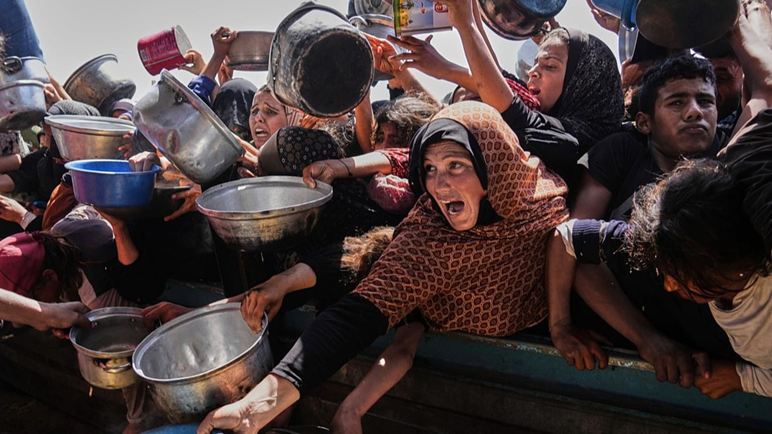 فلسطينيون يكافحون للحصول على الطعام في مطبخ جماعي بمدينة خان يونس جنوب قطاع غزة، الجمعة 9 أيار/مايو 2025.