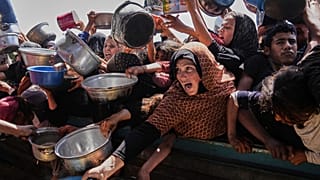 فلسطينيون يكافحون للحصول على الطعام في مطبخ جماعي بمدينة خان يونس جنوب قطاع غزة، الجمعة 9 أيار/مايو 2025.