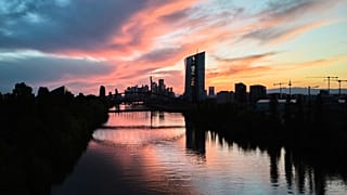Güneş, Almanya'nın Frankfurt kentinde, ön plandaki Avrupa Merkez Bankası binasının arkasında batıyor. 26 Nisan 2025.
