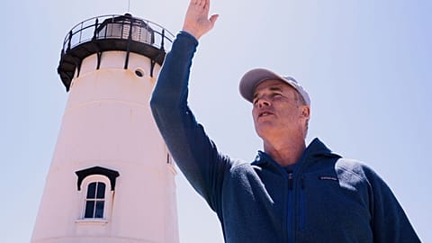 O nadador de resistência Lewis Pugh aponta para o local onde vai começar a sua travessia a nado à volta da ilha de Martha's Vineyard, que deverá durar 12 dias.