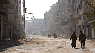 الناس يسيرون تحت الأعلام الفلسطينية في مخيم اليرموك في دمشق سوريا 2022