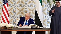 الرئيس دونالد ترامب يوقع على دفتر الزوار إلى جانب رئيس دولة الإمارات العربية المتحدة محمد بن زايد آل نهيان، الخميس 15 مايو/أيار 2025، في أبوظبي