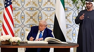 الرئيس دونالد ترامب يوقع على دفتر الزوار إلى جانب رئيس دولة الإمارات العربية المتحدة محمد بن زايد آل نهيان، الخميس 15 مايو/أيار 2025، في أبوظبي