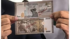 الصورة تعود إلى 24 يناير 2021 ويظهر فيها إياد بلال، مدير مديرية الخزينة يومها في مصرف سوريا المركزي، وهو يحمل الورقة النقدية من فئة 5000 ليرة سورية خلال مؤتمر صحفي بدمشق.