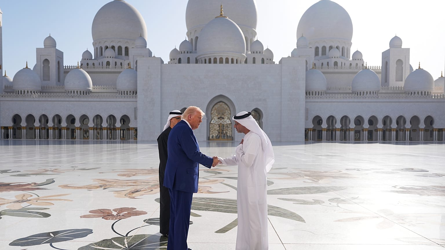 El presidente Donald Trump estrecha la mano de Yousif Al Obaidli, director de la Gran Mezquita Sheikh Zayed, durante una visita a la misma, el jueves 15 de mayo de 2025