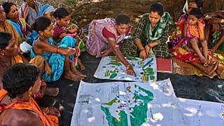 Kamala Kadria, della comunità indigena Gadaba, indica un punto su una mappa da loro realizzata nel villaggio di Hatipakna, nel distretto di Koraput, nello Stato orientale indiano di Odisha, nell'aprile 2025.