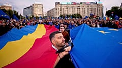 Demonstranten halten große rumänische und EU-Fahnen während einer Pro-EU-Kundgebung vor der zweiten Runde der Präsidentschaftswahlen in Bukarest, Rumänien, 9. Mai 2025