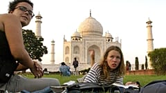 Turistler Hindistan'ın Agra kentindeki Tac Mahal'in çimlerinde oturuyor.
