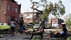 Un uomo siede su una sedia dopo che una forte tempesta ha attraversato St. Louis, Missouri, venerdì 16 maggio 2025.