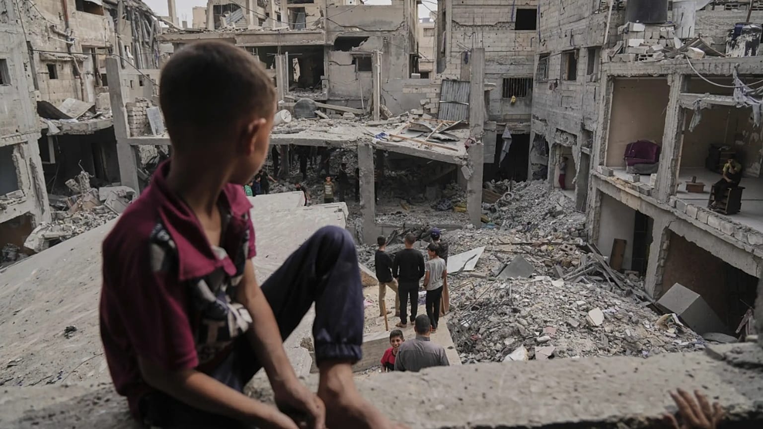 طفل فلسطيني يجلس على ركام منزله في غزة