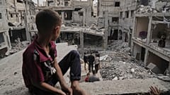 طفل فلسطيني يجلس على ركام منزله في غزة