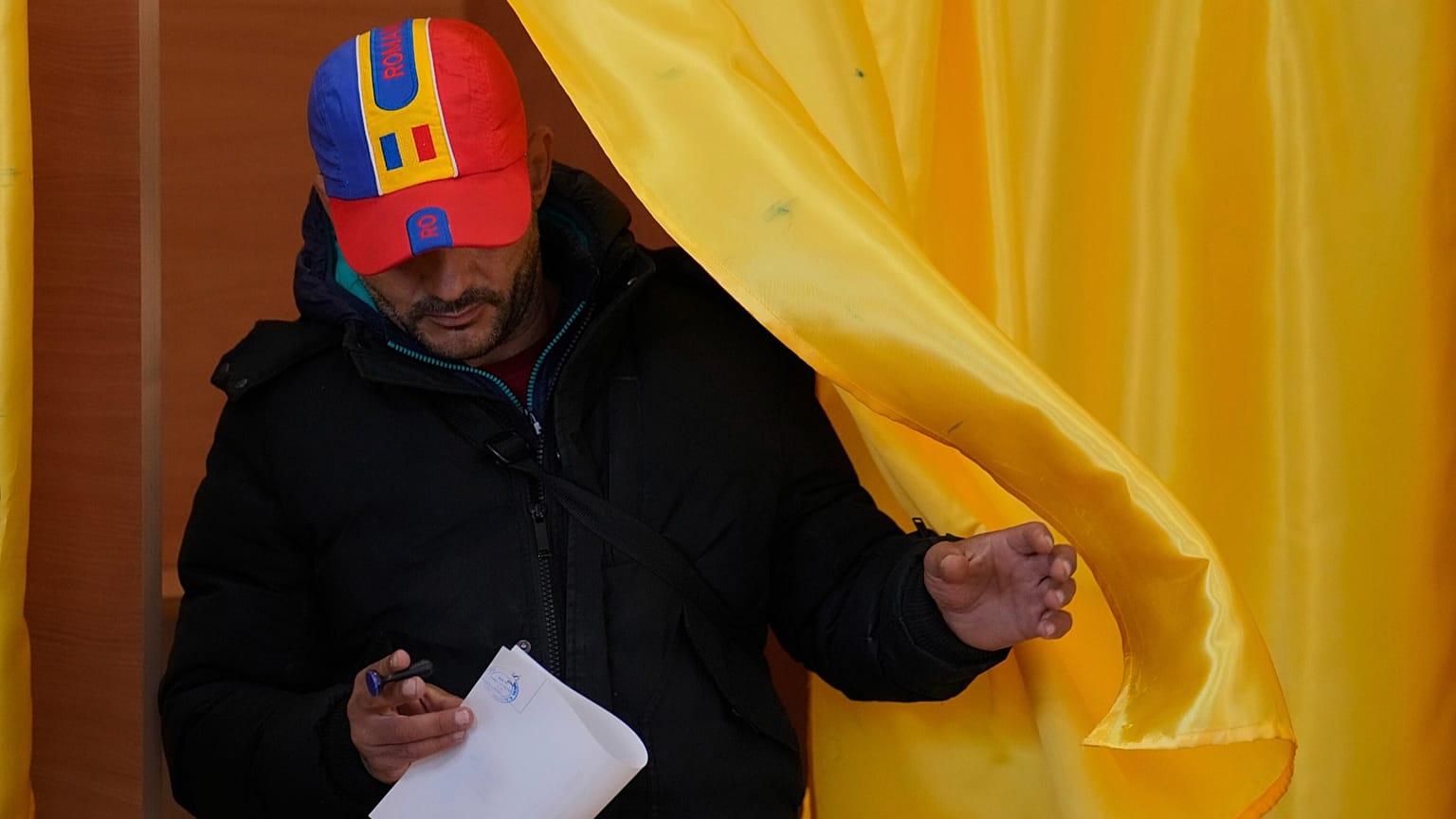 Un hombre sale de una cabina de votación antes de depositar su voto en la segunda vuelta de la repetición de las elecciones presidenciales del país, 18 de mayo de 2025.