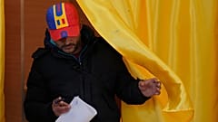 Un hombre sale de una cabina de votación antes de depositar su voto en la segunda vuelta de la repetición de las elecciones presidenciales del país, 18 de mayo de 2025.