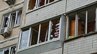 DOSYA: Rusya'nın Kiev'deki insansız hava aracı saldırısının ardından bir apartman sakini kırılan pencereden dışarı bakıyor, 4 Mayıs 2025