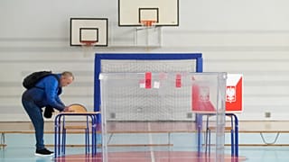Les électeurs votent dans les bureaux de vote ouverts lors du premier tour de l'élection présidentielle à Łomianki, près de Varsovie, le dimanche 18 mai 2025.