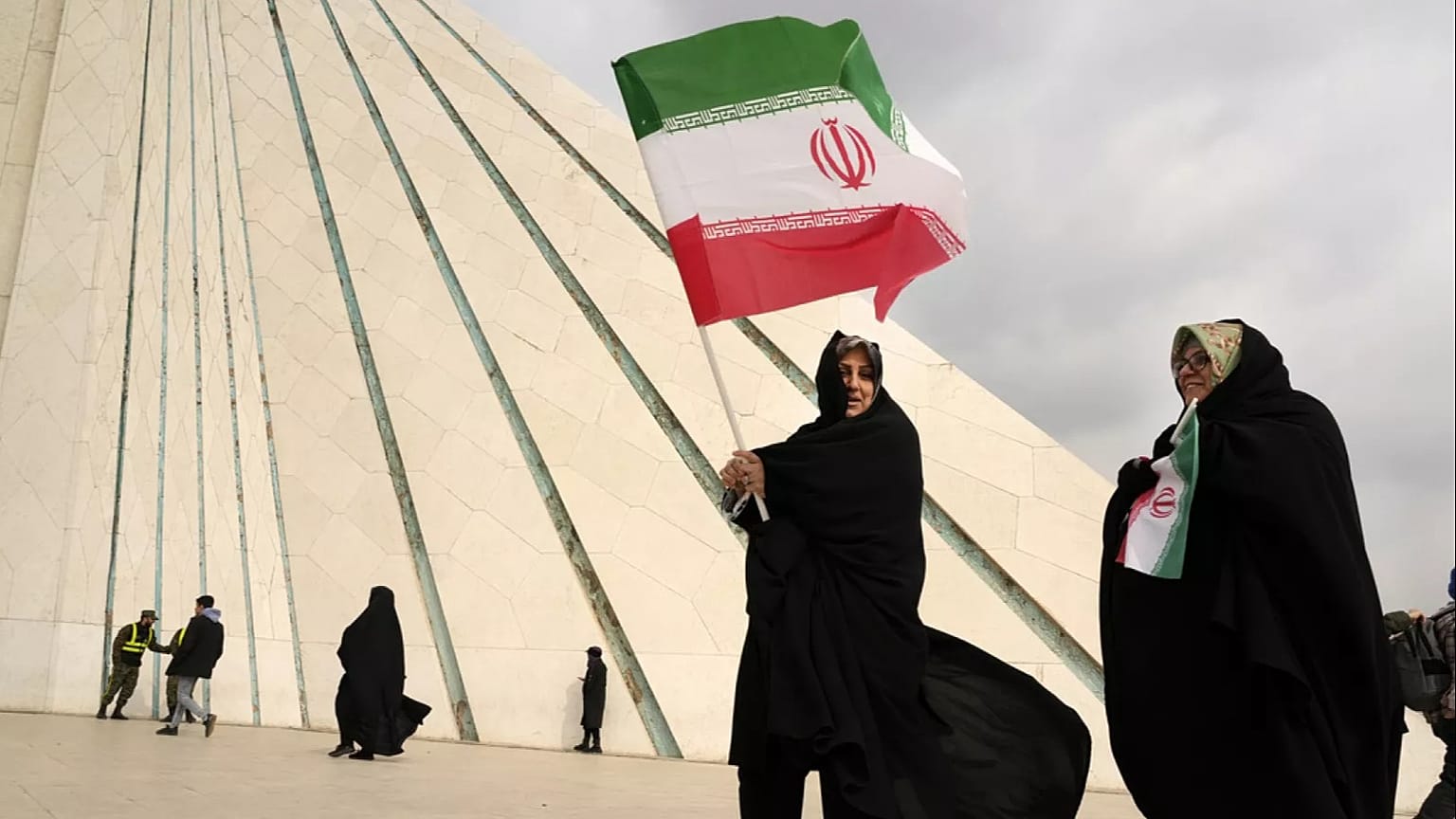 نساء يرفعن الأعلام الإيرانية قرب برج "آزادي" في طهران خلال إحياء ذكرى الثورة الإسلامية عام 1979، الإثنين 10 شباط/ فبراير 2025.