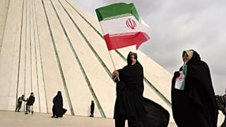 نساء يرفعن الأعلام الإيرانية قرب برج "آزادي" في طهران خلال إحياء ذكرى الثورة الإسلامية عام 1979، الإثنين 10 شباط/ فبراير 2025.
