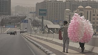 ARCHIVO: Vendedores de algodón de azúcar caminan durante un clima polvoriento, antes de la esperada tormenta de arena, en El Cairo, 30 de abril de 2025.