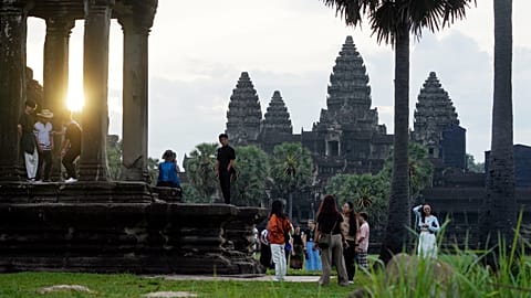 Tourists watch sunrise at the Angkor Wat temple in Siem Reap province, 2 August, 2024