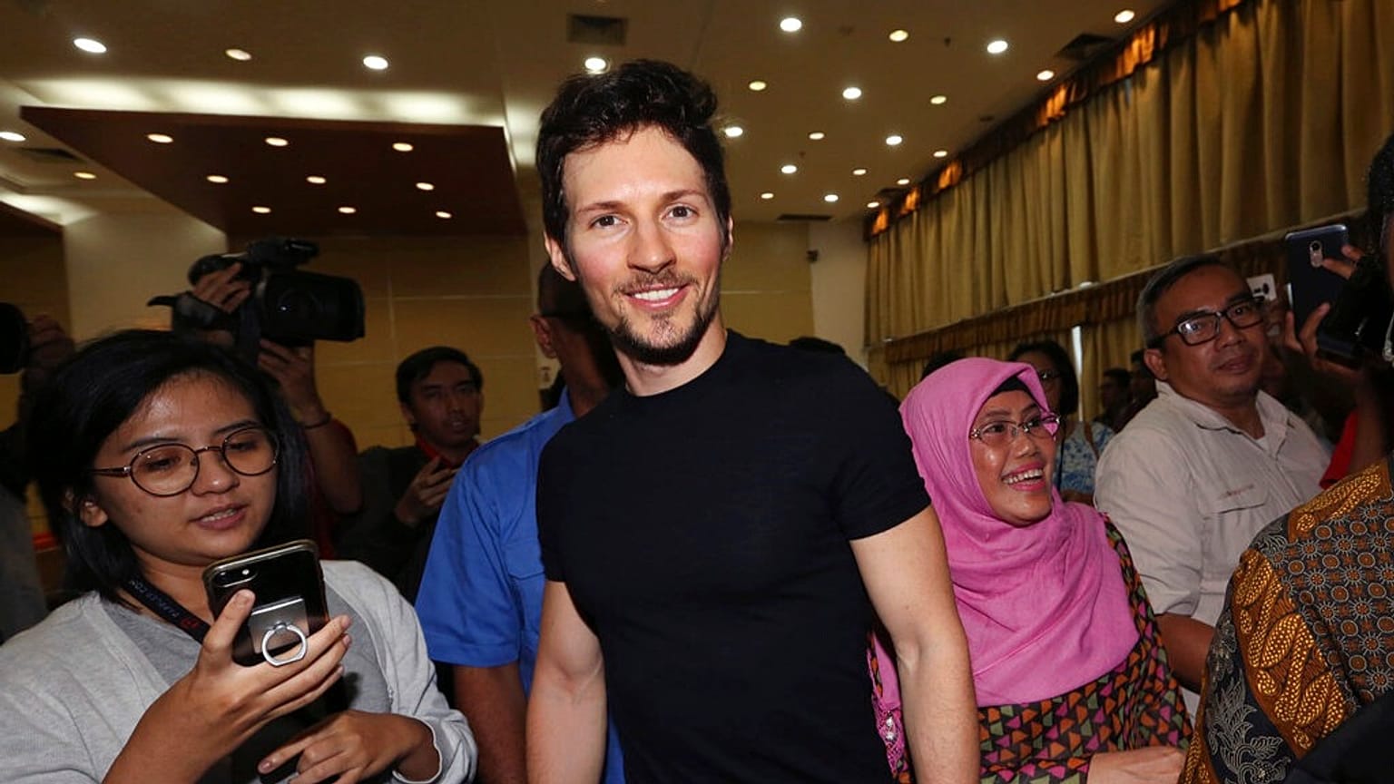 O cofundador do Telegram, Pavel Durov, ao centro, sorri ao sair após uma conferência de imprensa em Jacarta, Indonésia, na terça-feira, 1 de agosto de 2017. 