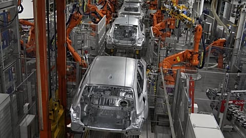 Robots work on cars of German car manufacturer BMW at an assembly line in Munich, Germany, Friday, Oct. 22, 2021. 