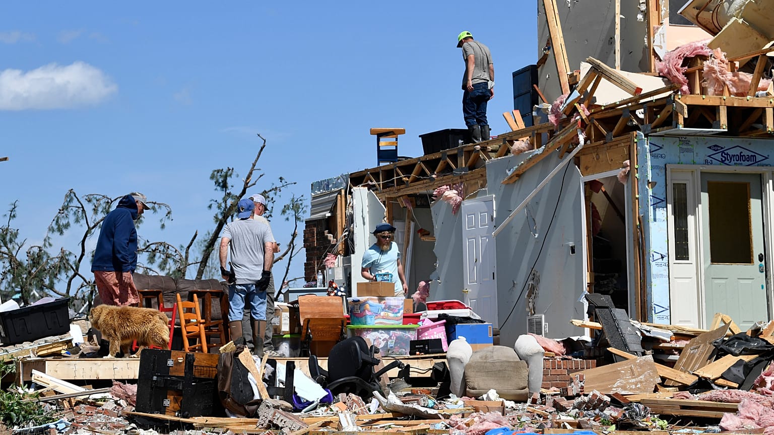 Familiares vasculham os destroços da sua casa destruída por uma forte tempestade em London, Kentucky, no sábado, 17 de maio de 2025