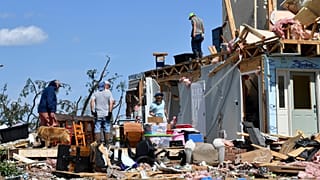 Familiares vasculham os destroços da sua casa destruída por uma forte tempestade em London, Kentucky, no sábado, 17 de maio de 2025