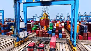 İşçiler 16 Mayıs 2025 tarihinde Çin'in doğusundaki Shandong eyaletinin Qingdao kentinde bir konteyner terminalinde konteyner yüklüyor.