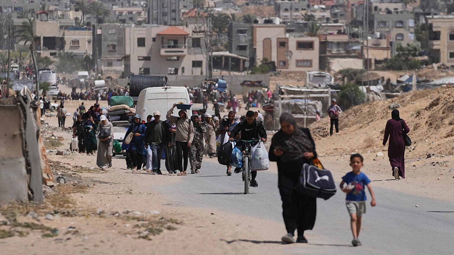 Palestinianos deslocados fogem de Khan Younis, Gaza, no meio da ofensiva militar israelita em curso na zona, na segunda-feira, 19 de maio de 2025.
