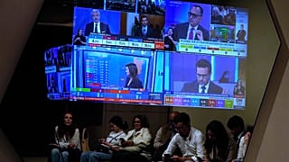 Apoiantes da coligação de centro-direita do primeiro-ministro Luís Montenegro consultam os resultados preliminares das eleições legislativas em Portugal, em Lisboa, no domingo