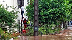 Un equipo de rescate ayuda a un hombre a salir de su casa en Cambo-Les-Bains, suroeste de Francia, viernes 4 de julio de 2014.